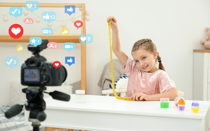 Image of Cute little blogger with slime recording video at home