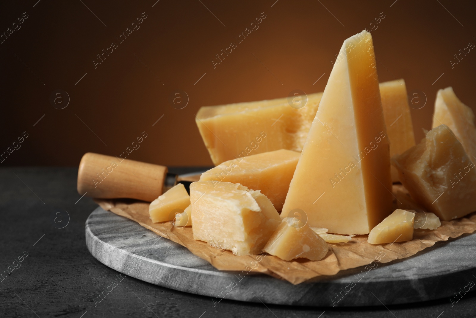 Photo of Marble board with delicious cheese on table, closeup