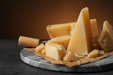 Photo of Marble board with delicious cheese on table, closeup