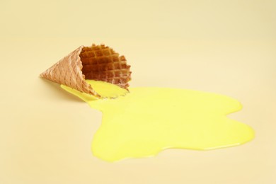 Photo of Melted ice cream and wafer cone on yellow background