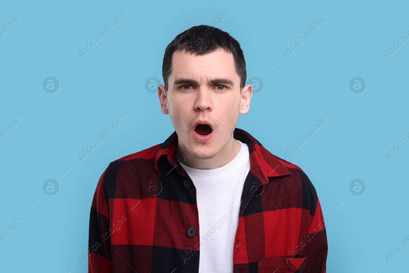 Photo of Portrait of surprised man on light blue background