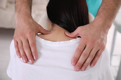 Photo of Woman receiving massage in modern chair indoors, closeup