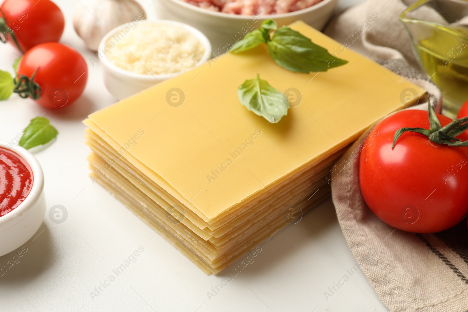 Photo of Ingredients for lasagna on white table, closeup