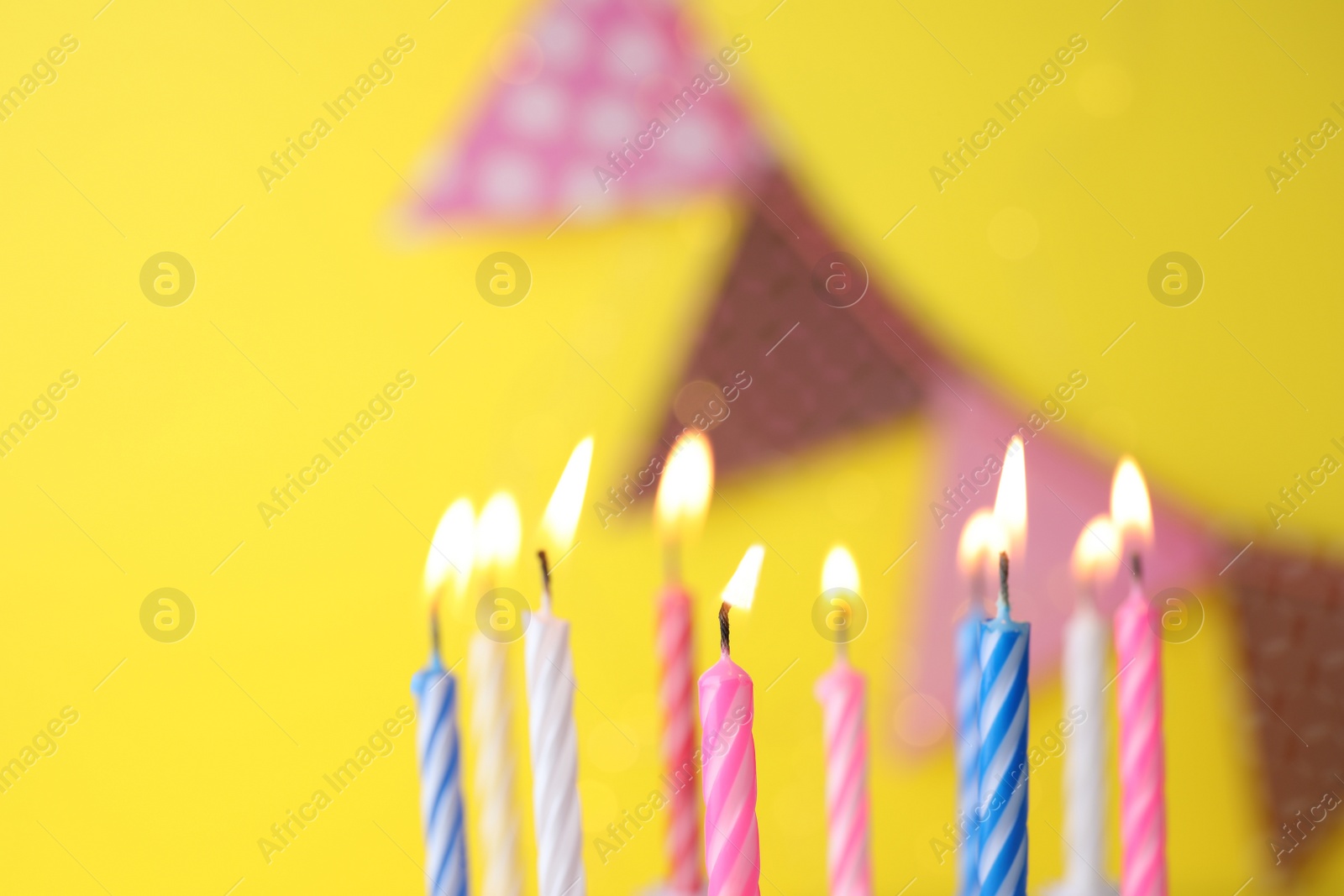 Photo of Burning birthday cake candles on color background. Space for text