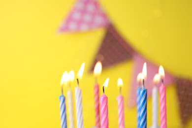 Photo of Burning birthday cake candles on color background. Space for text