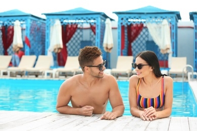 Photo of Woman in bikini with boyfriend at resort. Happy young couple