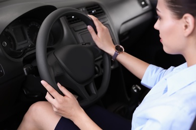 Prospective buyer holding hands on automobile steering wheel. Test drive