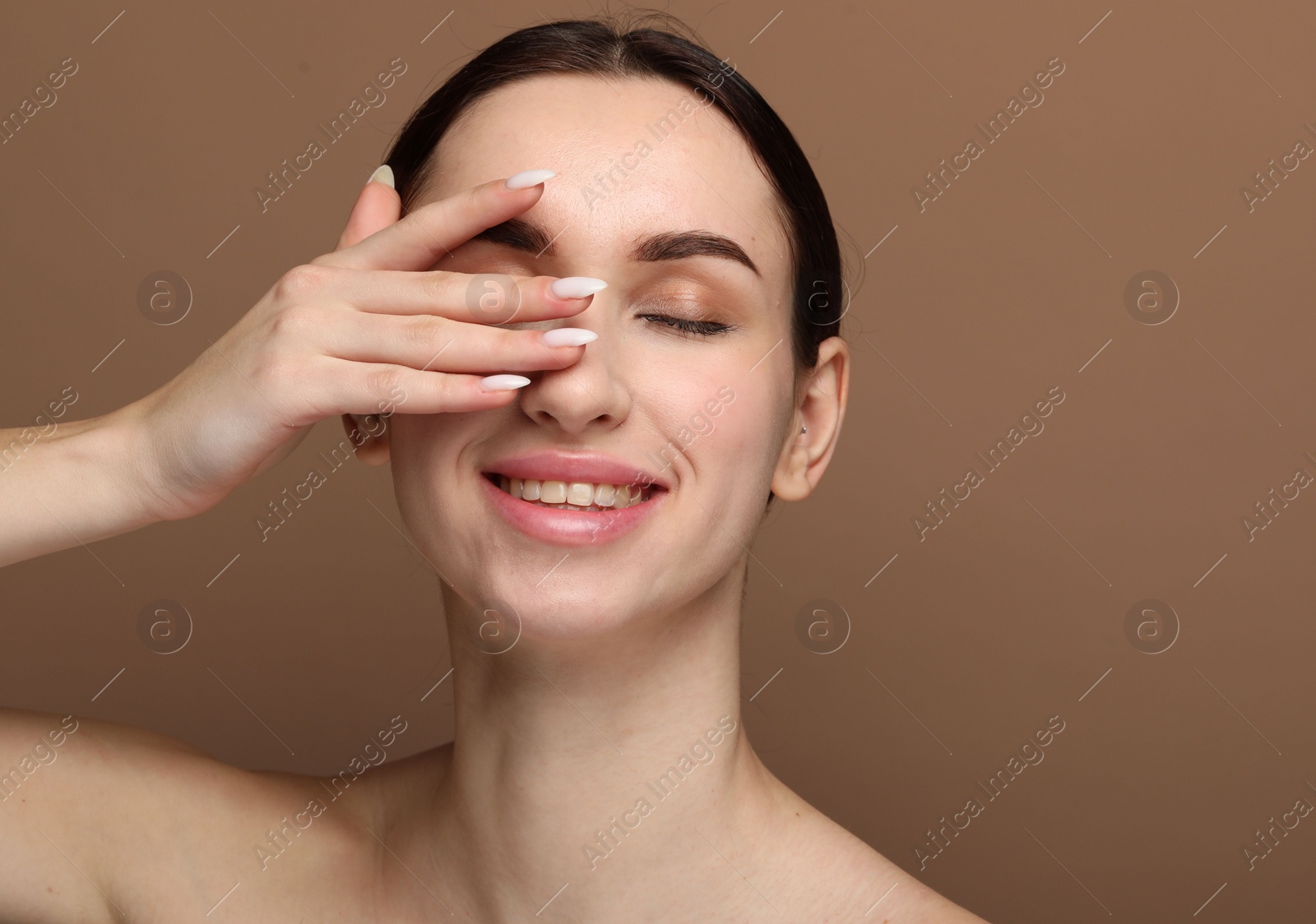 Photo of Portrait of beautiful young woman on brown background. Space for text