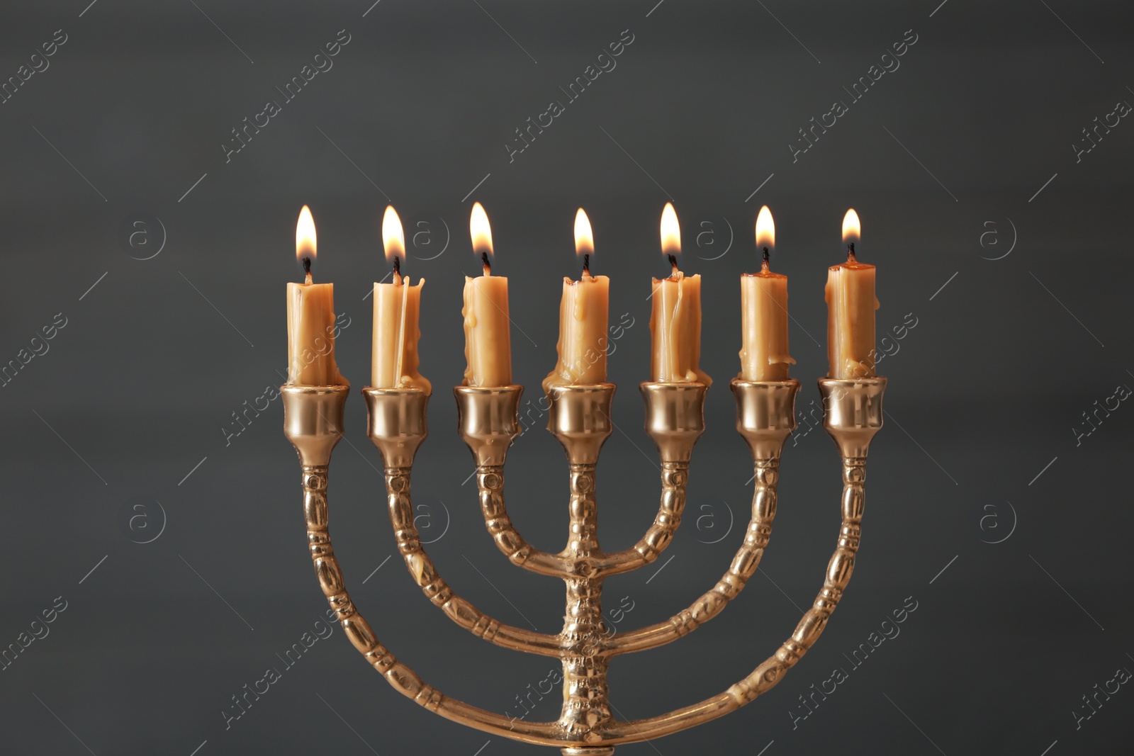 Photo of Golden menorah with burning candles on blurred background