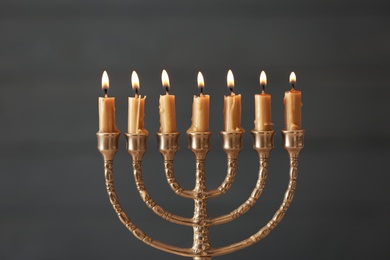 Photo of Golden menorah with burning candles on blurred background
