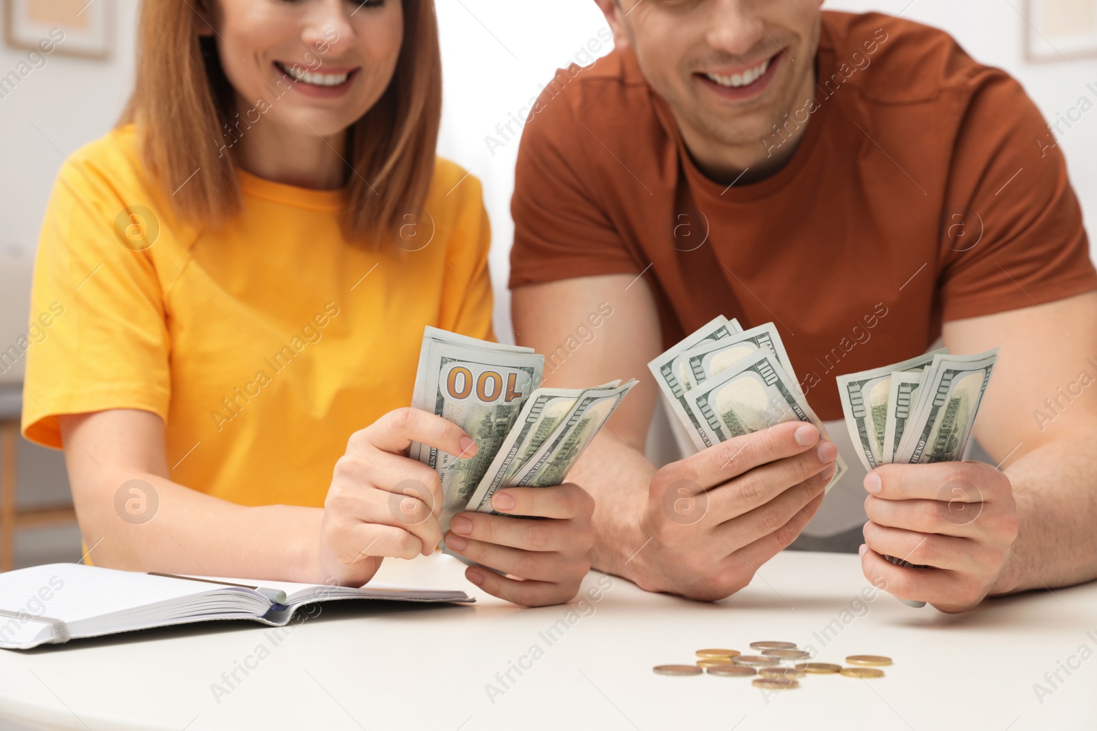 Photo of Couple counting money at table indoors, closeup