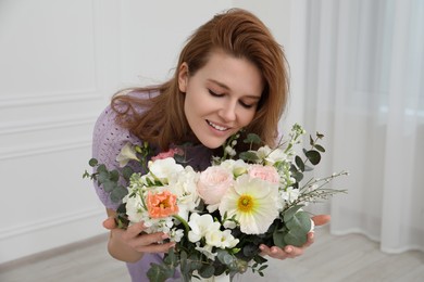 Photo of Beautiful woman with bouquet of flowers indoors