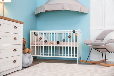 Photo of Modern interior of light cozy baby room with crib