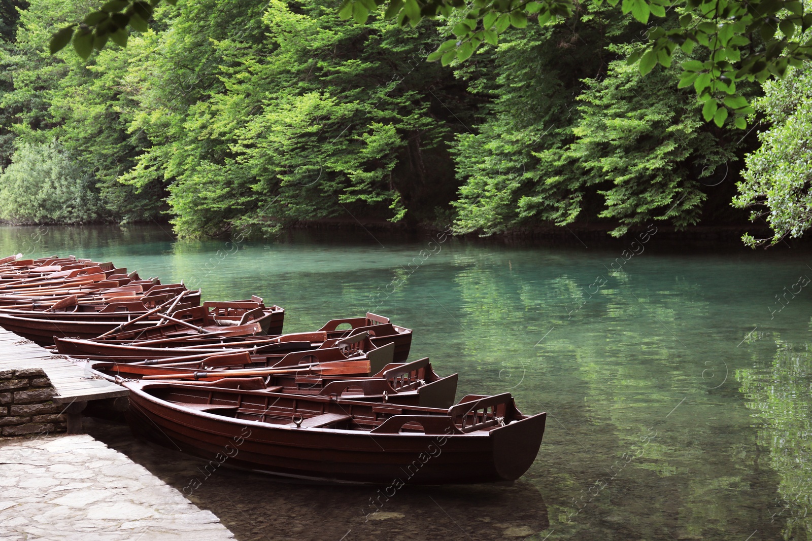 Photo of Picturesque view of river with boats at wooden pier