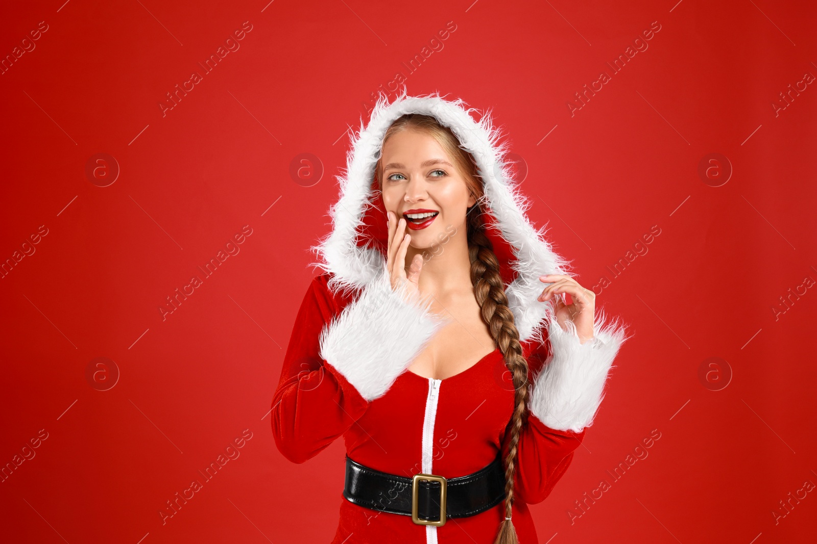 Photo of Beautiful Santa girl on red background. Christmas eve