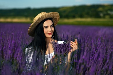 Beautiful young woman with bouquet in lavender field