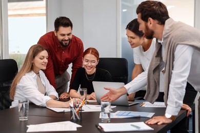 Photo of Team of employees working together in office