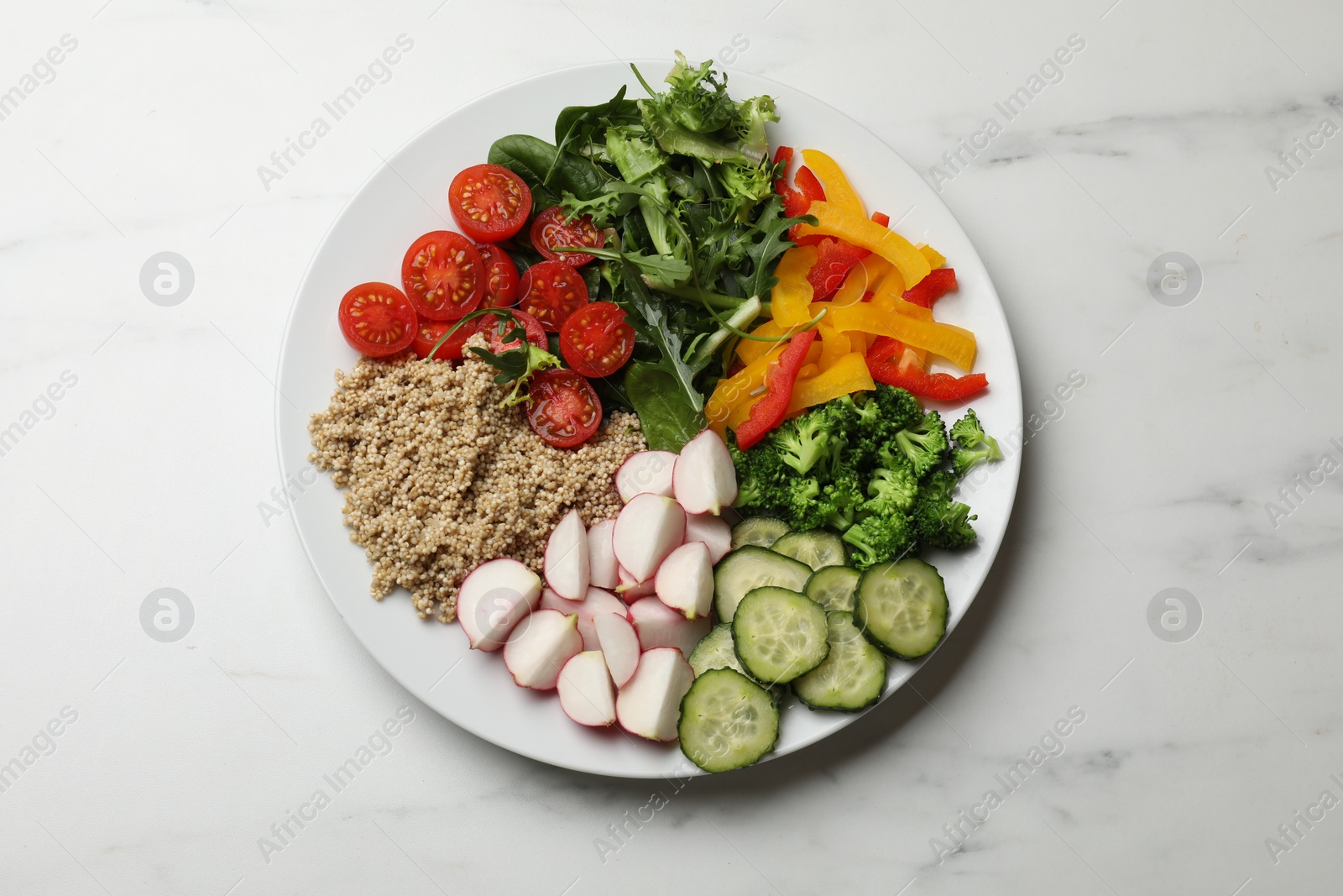 Photo of Vegetarian diet. Plate with tasty vegetables and quinoa on white marble table, top view