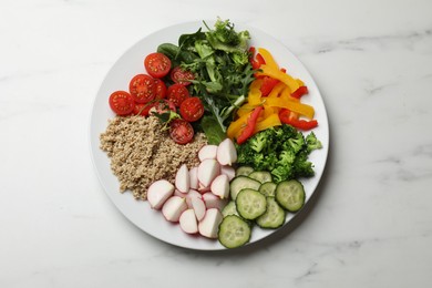 Vegetarian diet. Plate with tasty vegetables and quinoa on white marble table, top view