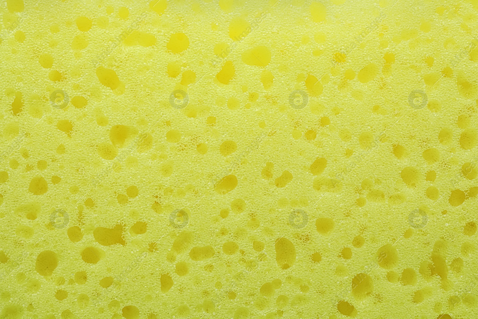 Photo of New yellow sponge as background, closeup view