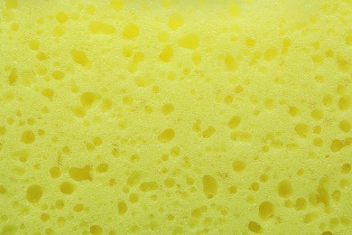 Photo of New yellow sponge as background, closeup view