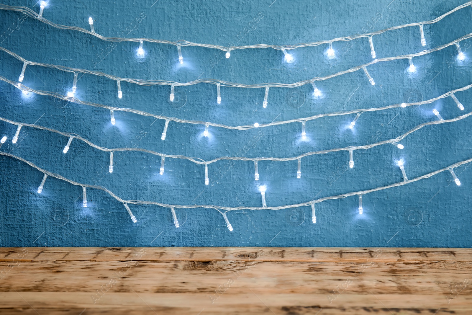 Photo of Beautiful bright Christmas lights on color background