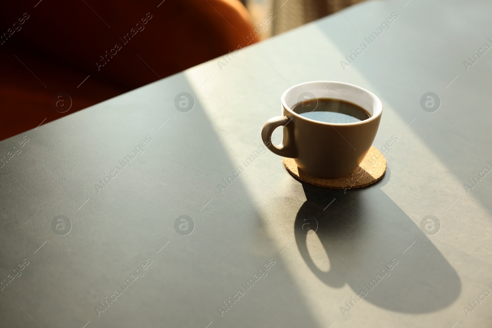 Photo of Cup of delicious coffee on grey table indoors, space for text