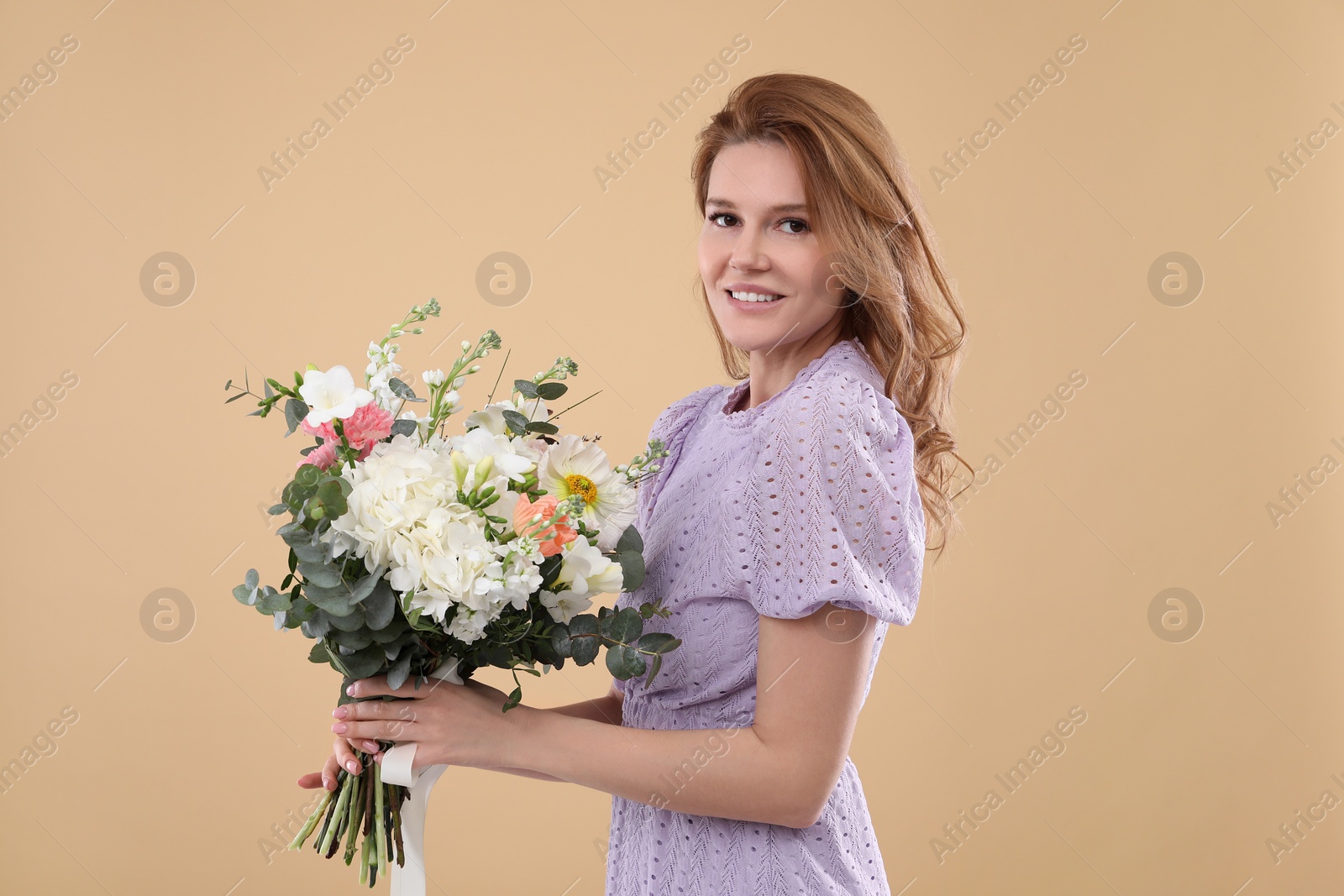 Photo of Beautiful woman with bouquet of flowers on beige background