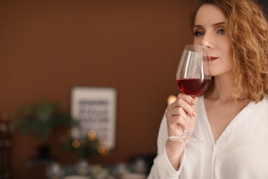 Photo of Woman with glass of delicious wine indoors