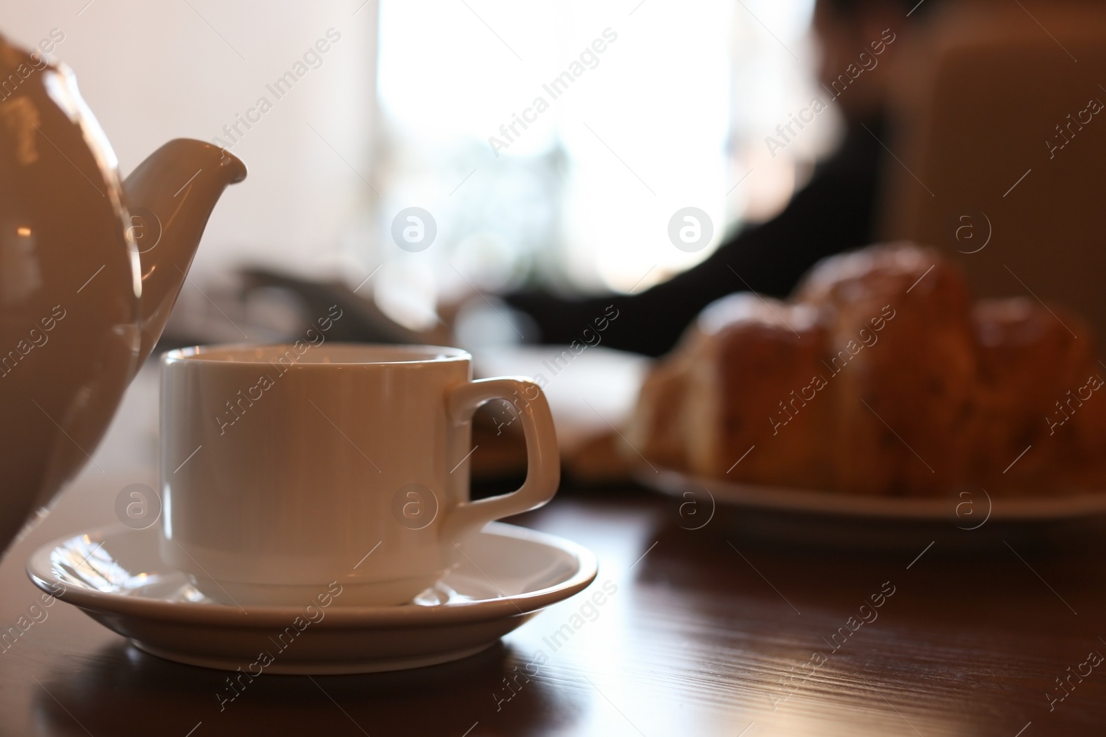 Photo of Delicious morning coffee and croissant served for breakfast on wooden table