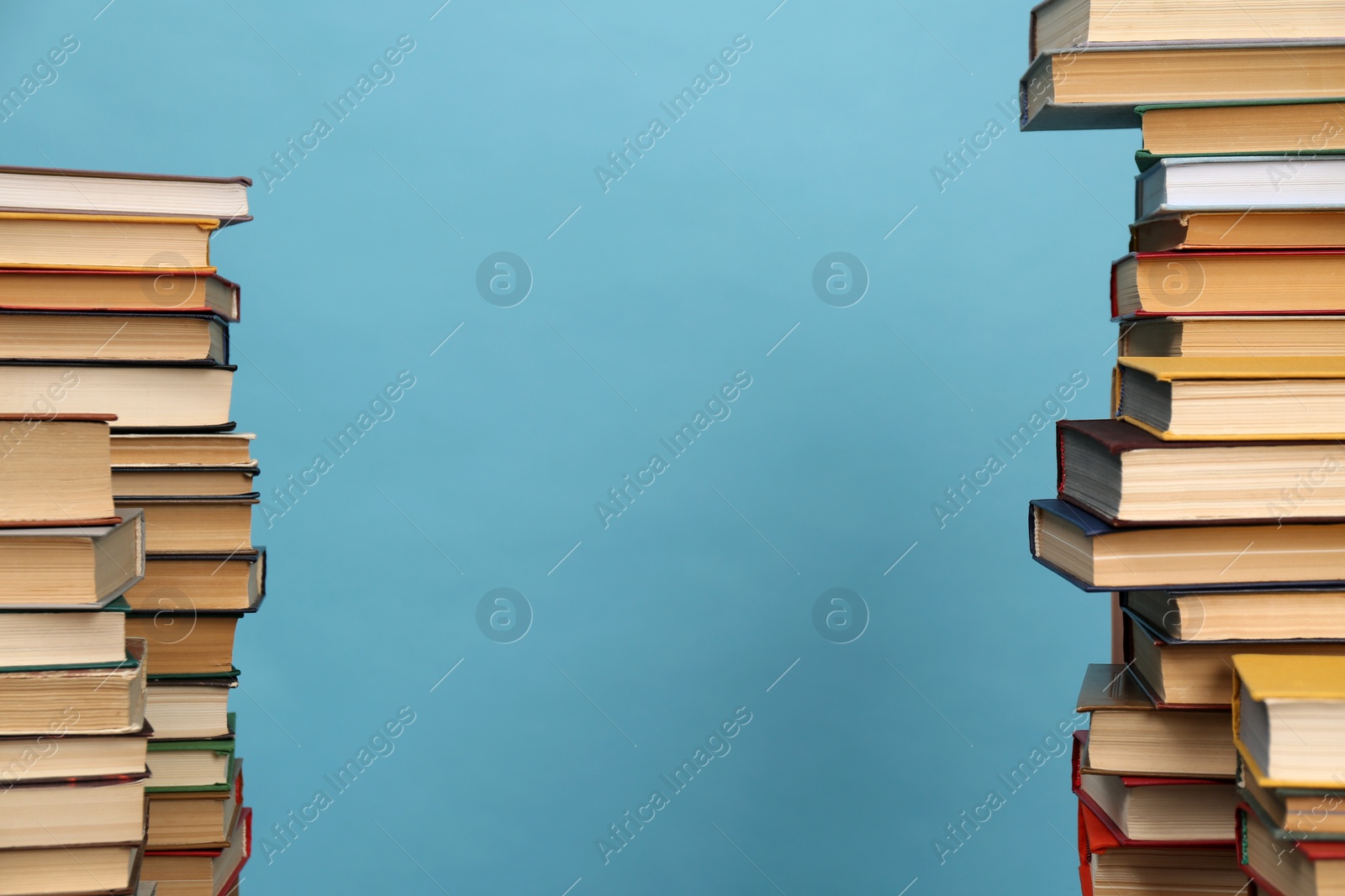 Photo of Many hardcover books on turquoise background, space for text. Library material