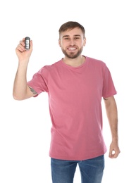 Happy young man with car key on white background. Getting driving license