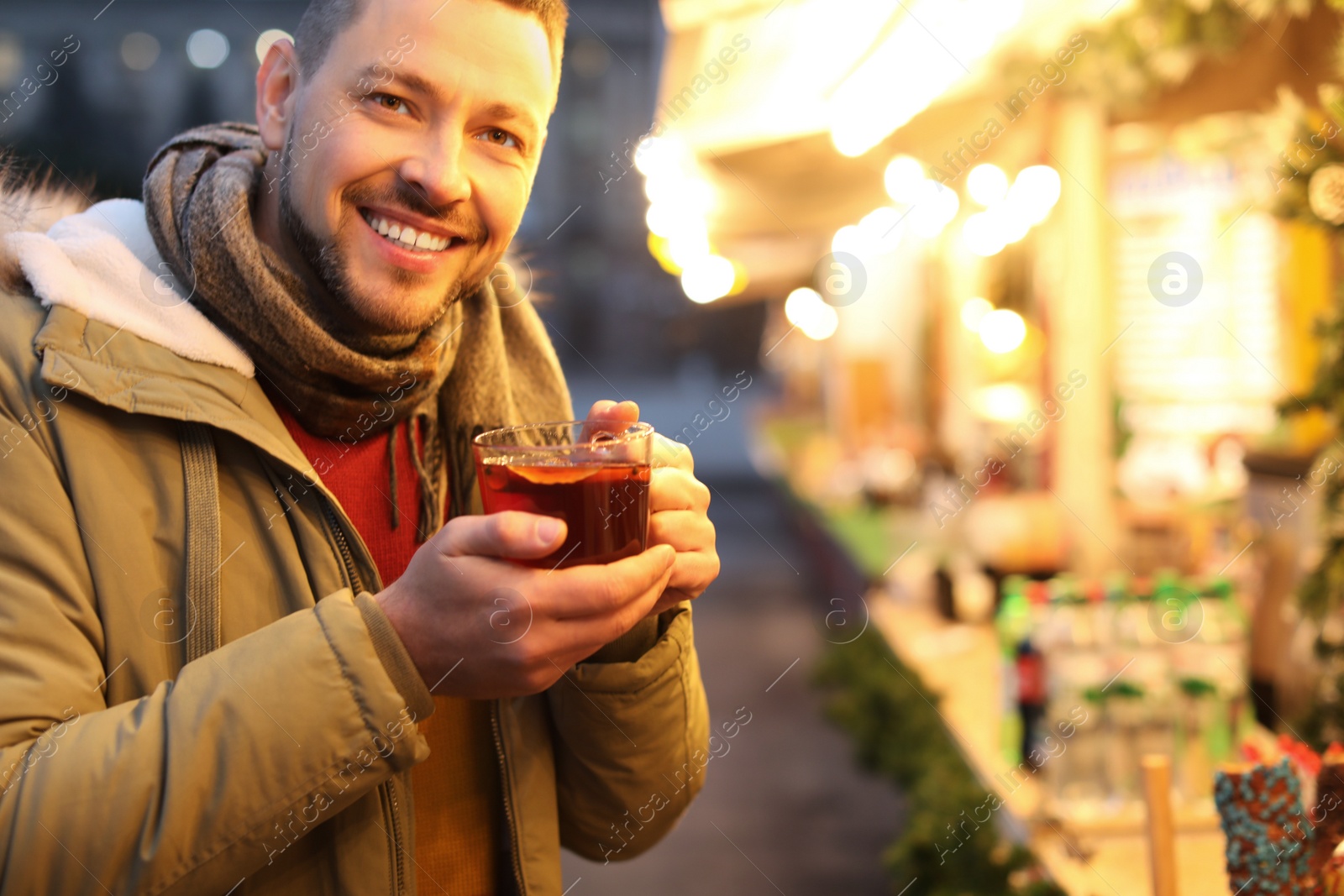 Photo of Happy man with mulled wine at winter fair