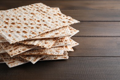 Photo of Stack of matzos on wooden table, closeup. Space for text
