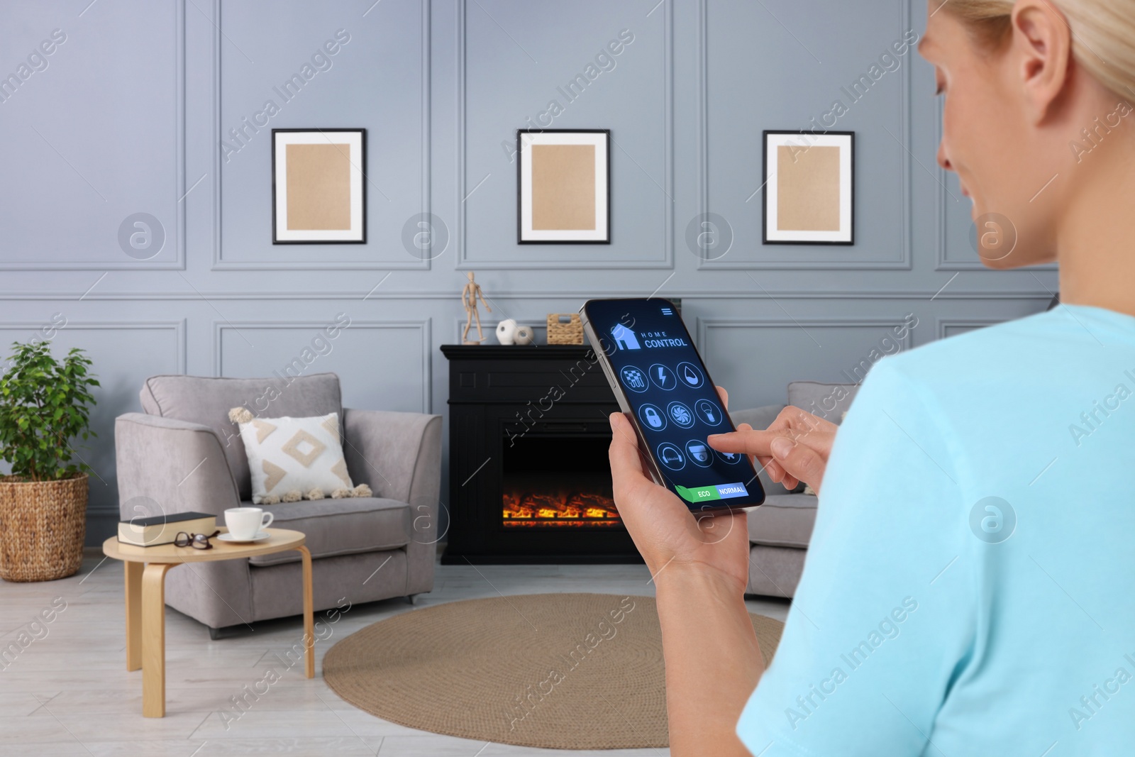 Image of Woman using smart home control system via application on mobile phone indoors, closeup