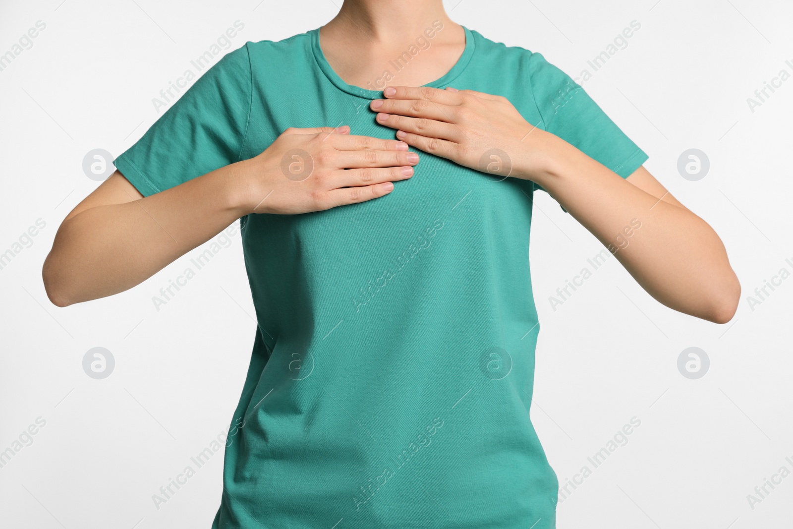 Photo of Woman holding hands near chest on light grey background, closeup