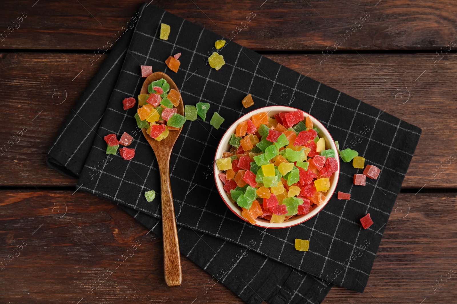 Photo of Mix of delicious candied fruits on wooden table, flat lay