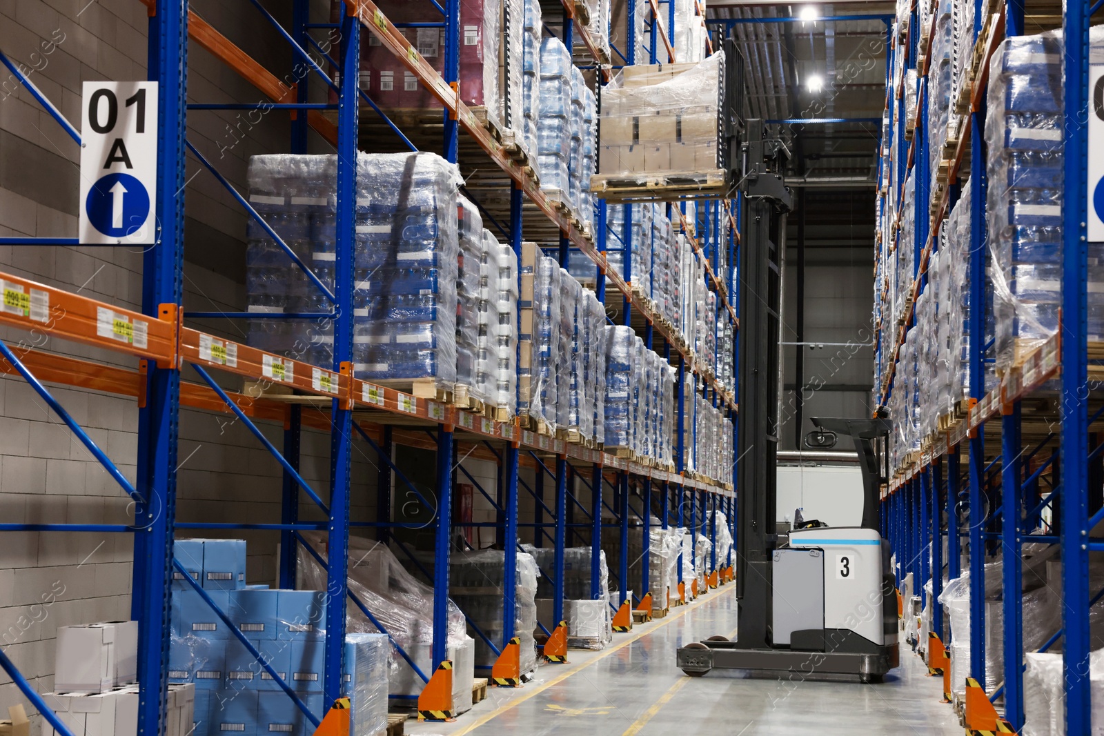 Photo of Warehouse interior with metal racks full of merchandise. Wholesale business