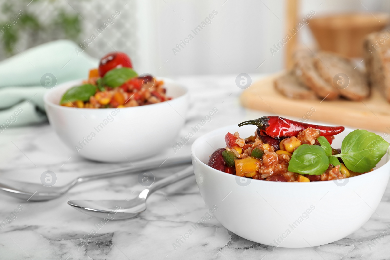 Photo of Tasty chili con carne served on marble table. Space for text