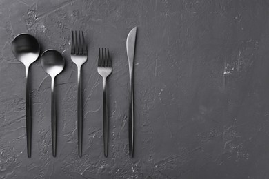 Photo of Beautiful cutlery set on black table, flat lay. Space for text