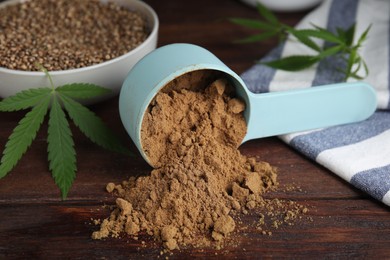 Hemp protein powder, seeds and fresh leaf on wooden table, closeup