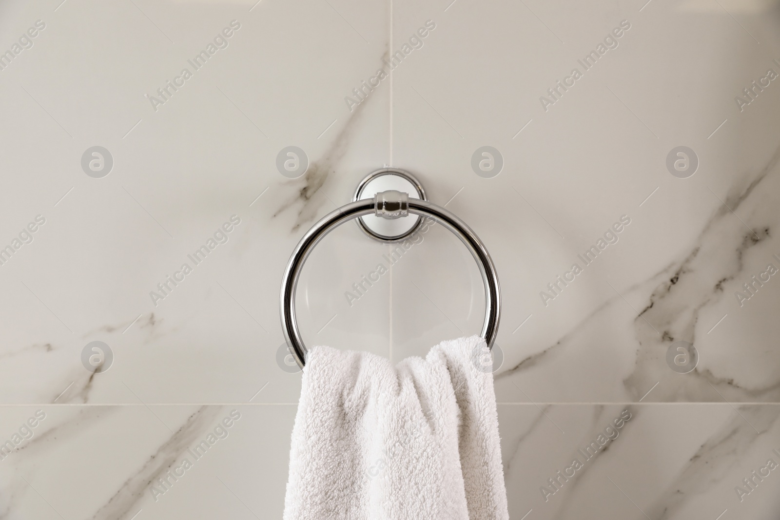 Photo of Holder with clean towel on light wall