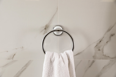 Photo of Holder with clean towel on light wall