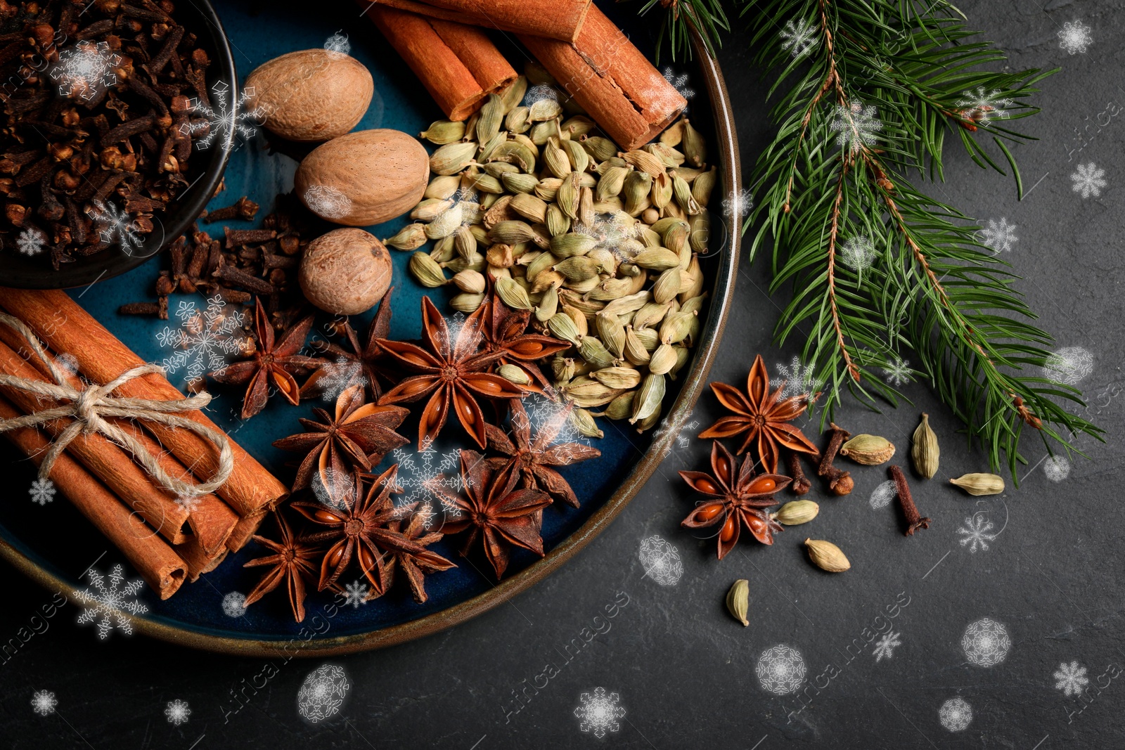 Image of Different spices and fir tree branches on black background, top view. Cinnamon, cloves, anise, cardamom, nutmegs