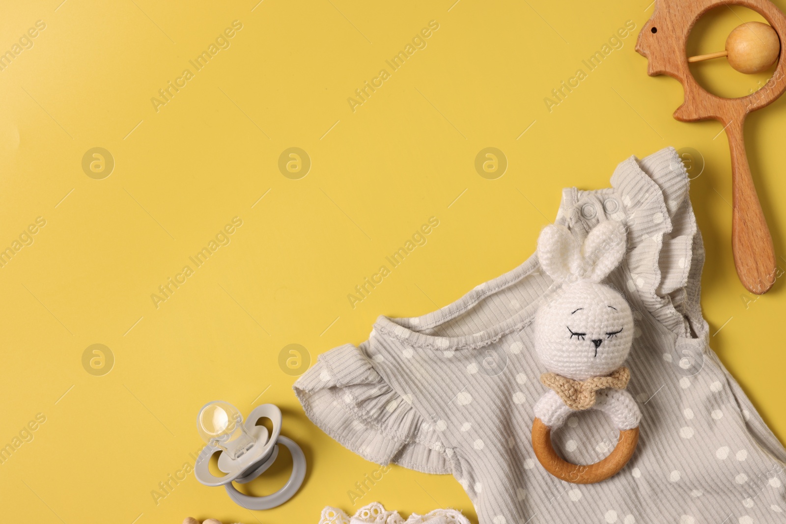 Photo of Different baby accessories on yellow background, flat lay. Space for text