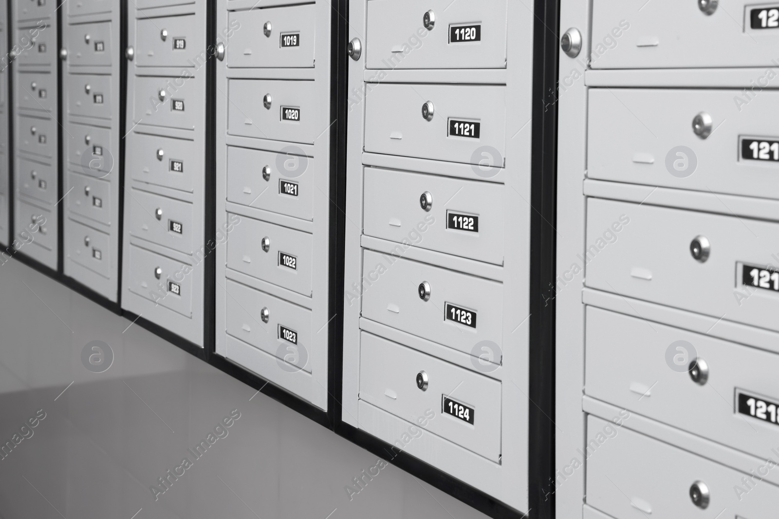 Photo of Closed metal mailboxes with keyholes and sequence numbers indoors