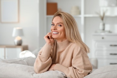 Photo of Portrait of laughing middle aged woman with blonde hair at home