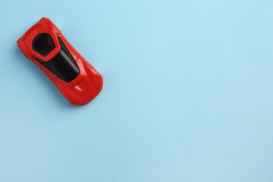 Photo of One red car on light blue background, top view with space for text. Children`s toy