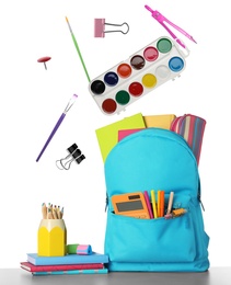 Image of School stationery flying over backpack on white background