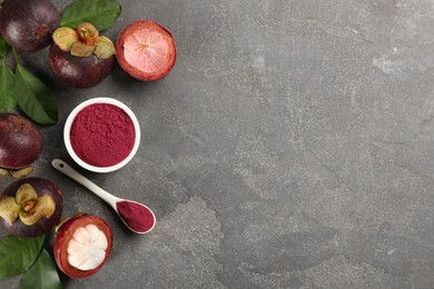 Purple mangosteen powder and fruits on grey table, flat lay. Space for text